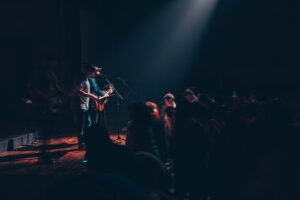 a man standing on a stage with a guitar